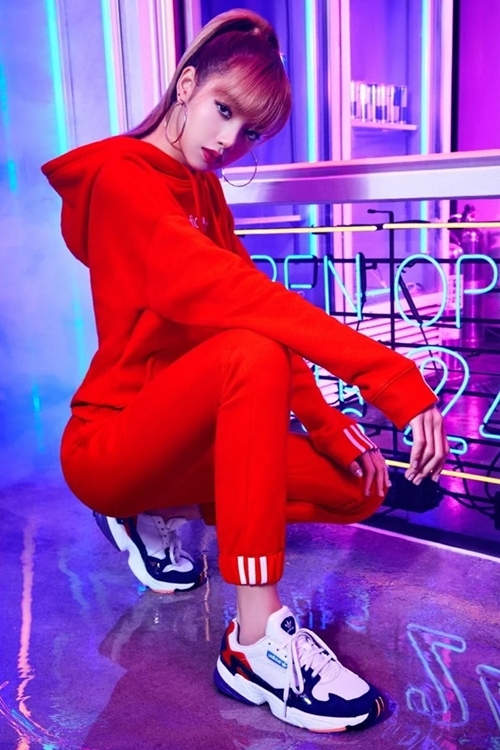 Ca sĩ Lisa nhóm Blackpink diện set đồ thể thao đỏ rực và giày Adidas Falcon. Mẫu sneaker này thu hút giới trẻ nhờ cách phối những mảng màu độc đáo, đế cao 3 cm giúp ăn gian chiều cao.