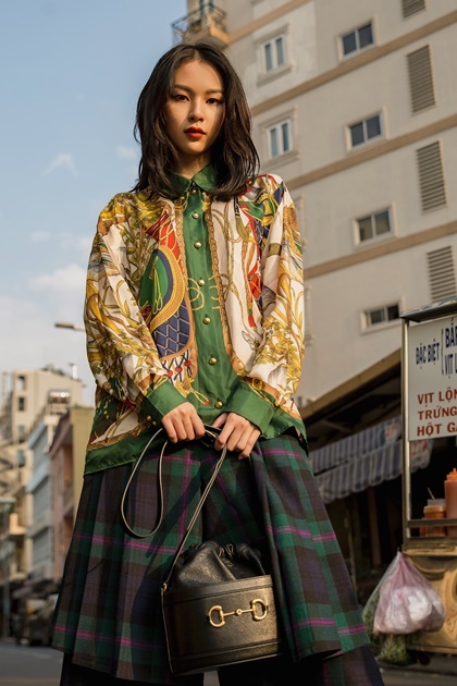 Quán quân The Face Phí Phương Anh cũng bắt kịp xu hướng với dòng túi mới. Cô phối túi chiếc xô với áo sơ mi họa tiết vương giả, quần kẻ sọc theo phong cách thu đông.